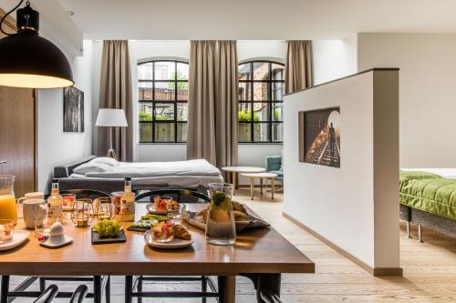 een woonkamer met een tafel met eten erop bij The More Hotel Lund in Lund