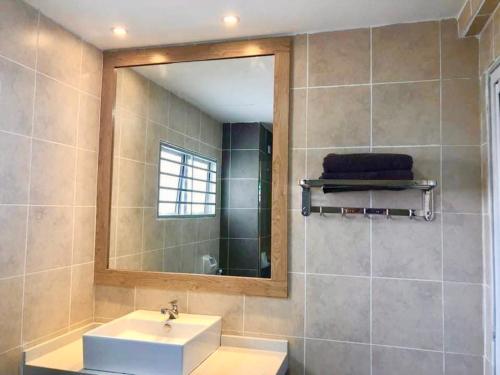 ein Bad mit einem Waschbecken und einem Spiegel in der Unterkunft Sofiamuslim Homestay Putrajaya in Putrajaya