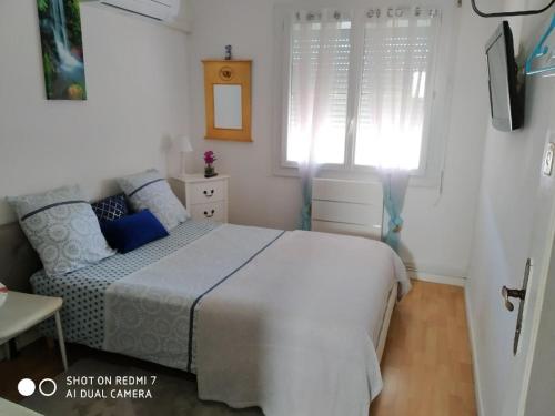 1 dormitorio con cama y ventana en CHAMBRE CONFORTABLE,Près Gare,CLIM,PARKING,pt déjeuner, en Perpiñán