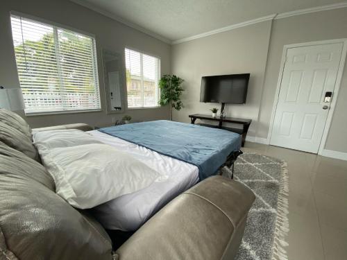 łóżko w pokoju z kanapą i telewizorem w obiekcie Marlins Park Suites - APT 2 - Gallo Suite w Miami