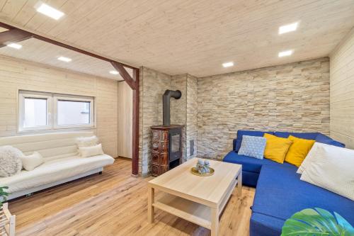 - un salon avec un canapé bleu et une cheminée dans l'établissement Chata Řeka, à Řeka