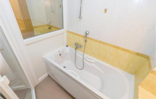 Beautiful Home In Kastav With Kitchen في كاستاف: حوض استحمام أبيض في حمام مع مرآة