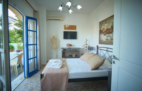 a living room with a bed and a sliding glass door at Logothetianika houses - Kithikies holiday houses in Kámbos