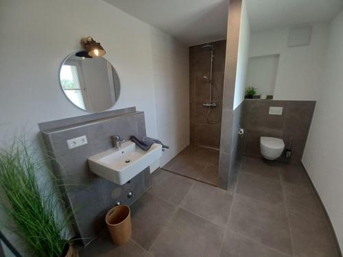 a bathroom with a sink and a shower and a mirror at Rösslerhof Ferienwohnung Obstwiese 
