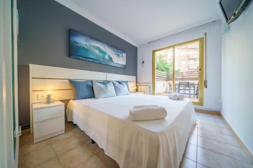 - une chambre avec un grand lit blanc et une fenêtre dans l'établissement HomeHolidaysRentals Liberty - Costa Barcelona, à Pineda de Mar