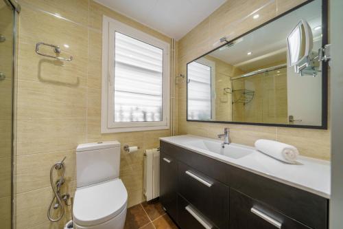 y baño con aseo, lavabo y espejo. en HomeHolidaysRentals Liberty - Costa Barcelona en Pineda de Mar