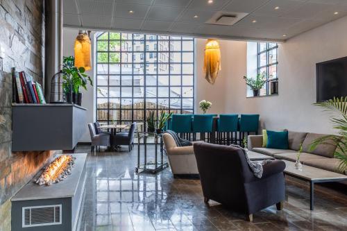 een lobby met banken en stoelen en een open haard bij The More Hotel Lund in Lund