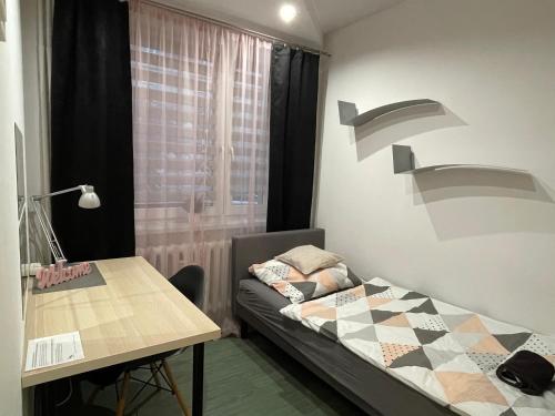 ソスノヴィエツにあるApartament Gospodarczaのベッドとテーブル付きの小さな部屋
