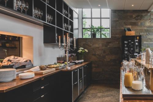 a kitchen with black cabinets and a counter with food at The More Hotel Lund in Lund