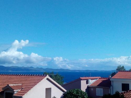 a view of the ocean from the roofs of houses at Apartments Mimose in Milna