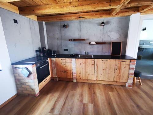 uma cozinha com um lavatório e um fogão num quarto em Rösslerhof Ferienwohnung Stiller Bach 