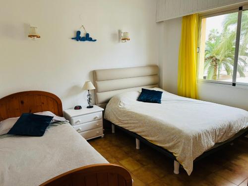 1 Schlafzimmer mit 2 Betten und einem Fenster in der Unterkunft Piso Los Angeles - 1ra Linea de Playa in Denia