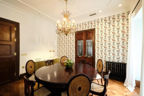 a dining room with a table and chairs and a chandelier at HOTEL BOUTIQUE VILLA DEL MARQUÉS in Muros de Nalón