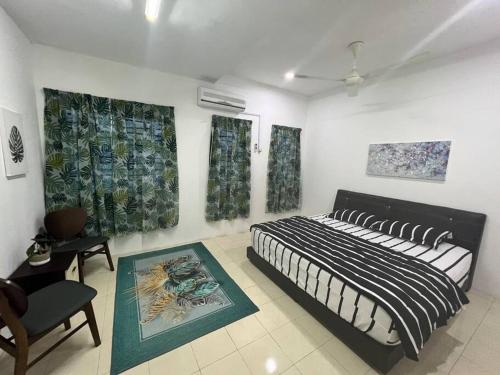 1 dormitorio con 1 cama, 1 silla y pinturas en RUMAH MURNI by IMPIAN HOMESTAY KLIA-SALAK TINGGI-NILAI, en Sepang