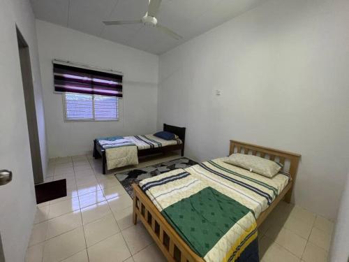 a bedroom with two beds and a window at RUMAH MURNI by IMPIAN HOMESTAY KLIA-SALAK TINGGI-NILAI in Sepang