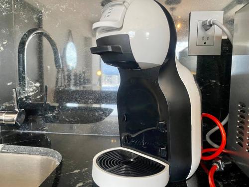 una macchinetta del caffè in bianco e nero seduta su un bancone di Exclusive Apartment With Jacuzzi Rockefeller a El Gallinero