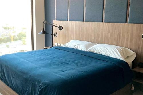 a bedroom with a blue bed with a large window at Exclusive Apartment With Jacuzzi Rockefeller in El Gallinero