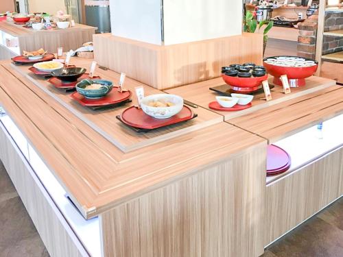 a buffet line with bowls and plates of food at LiVEMAX RESORT Sakurajima Sea Front in Tarumizu