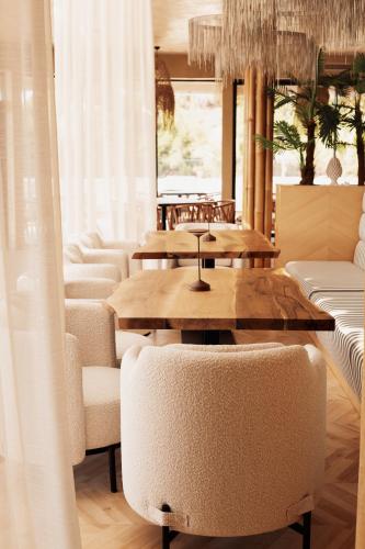 a dining room with tables and white chairs at White Hill Hotel, SPA & Conferences in Durrës