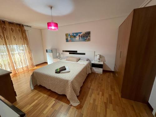 1 dormitorio con cama y luz rosa en A casiña do Rodri, en Ribadavia