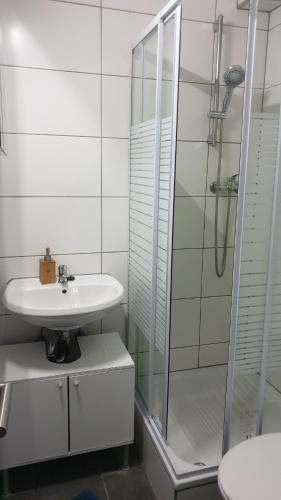 a white bathroom with a sink and a shower at Workers-Sleep-Station in Cologne