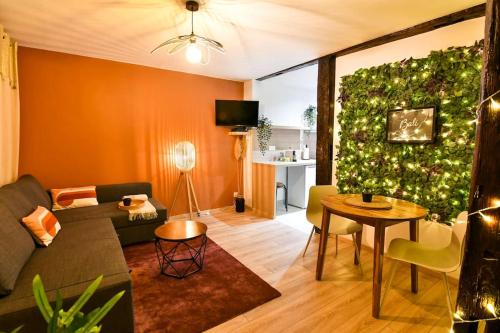 ein Wohnzimmer mit einem Sofa und einer grünen Wand in der Unterkunft Le Petit Bali in Sélestat