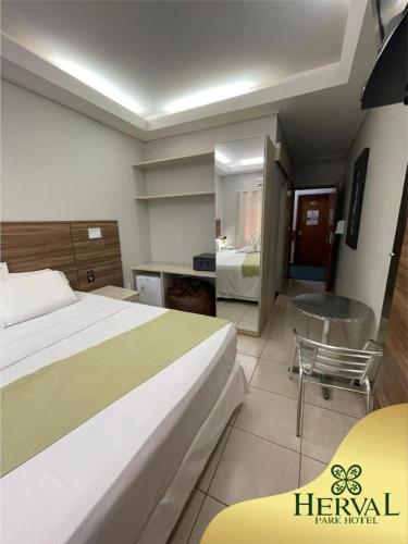 a hotel room with a large bed and a desk at Herval Park Hotel in Ponta Porã