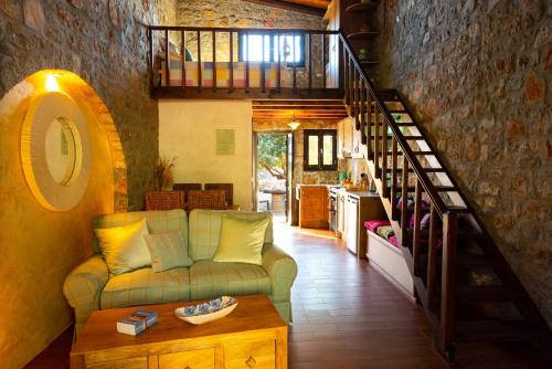 a living room with a couch and a staircase at Carob Cottage in Elounda