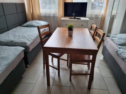 a small room with a table and chairs and a tv at Workers-Sleep-Station in Cologne