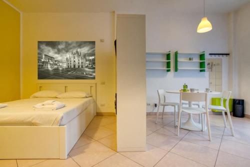 um quarto com uma cama e uma mesa com cadeiras em Il Giardino del naviglio-Studio em Milão