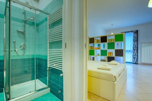 uma casa de banho com uma cama e uma cabina de duche em vidro em Il Giardino del naviglio-Studio em Milão