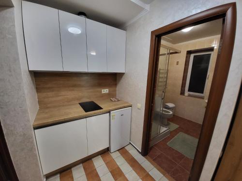 a small kitchen with white cabinets and a toilet at Veronika in Solochin