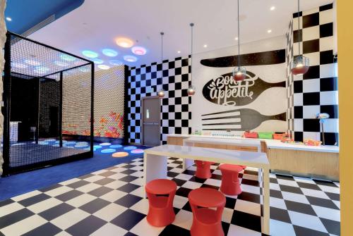 a restaurant with a checkered floor and a table and stools at Wyndham Doha West Bay in Doha