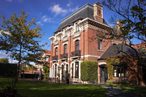 a brick building with a tower on top of it at La Villa Barbieux in Roubaix