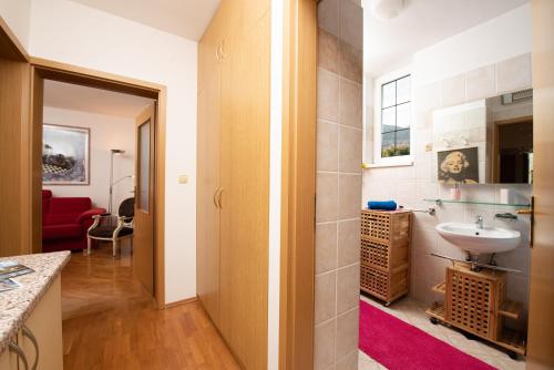 a bathroom with a sink and a mirror at Seaview Apartment Bosnjak Opatija in Ičići