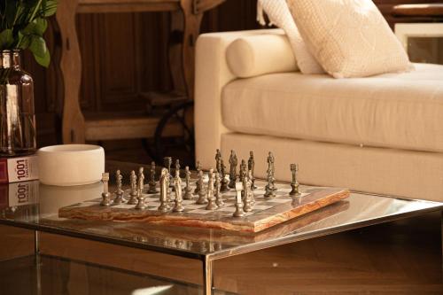 a chess set on a table in front of a couch at La Villa Barbieux in Roubaix