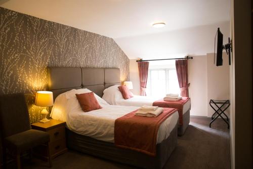 um quarto de hotel com duas camas e uma janela em George & Dragon, Conwy em Conwy