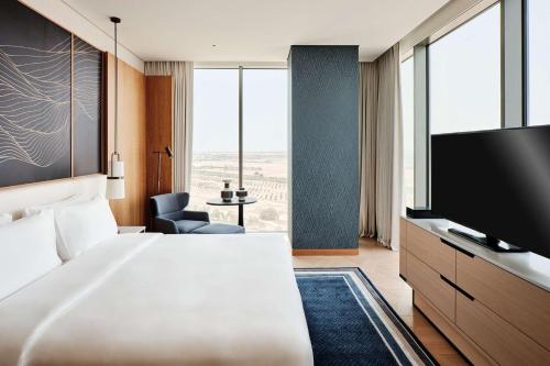 a hotel room with a bed and a flat screen tv at Grand Hyatt Kuwait in Kuwait