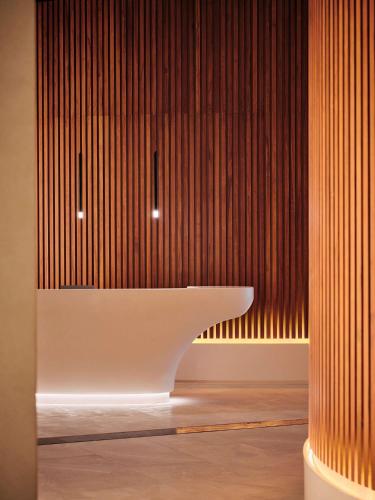 a bathroom with a white sink on a wood wall at Grand Hyatt Kuwait in Kuwait