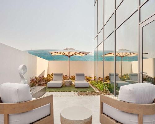 a patio with chairs and tables and umbrellas at Grand Hyatt Kuwait in Kuwait