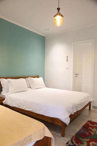 a bedroom with a large bed with white sheets at Agora Bed & Breakfast in Vlorë