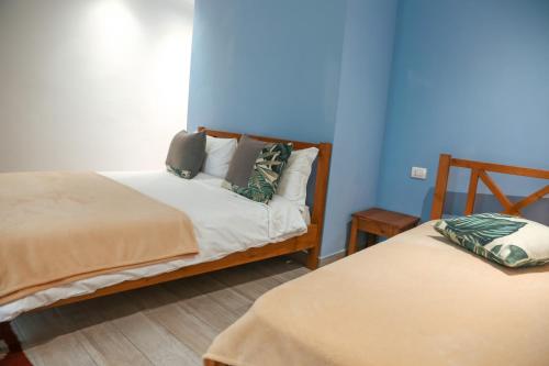 two beds in a room with blue walls at Agora Bed & Breakfast in Vlorë