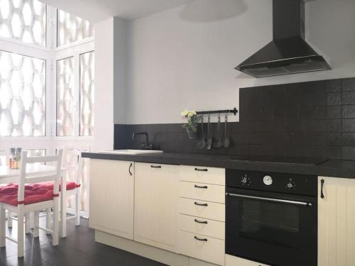 een keuken met een zwart aanrecht en een fornuis bij Spacious and light flat with beautiful views in Santander