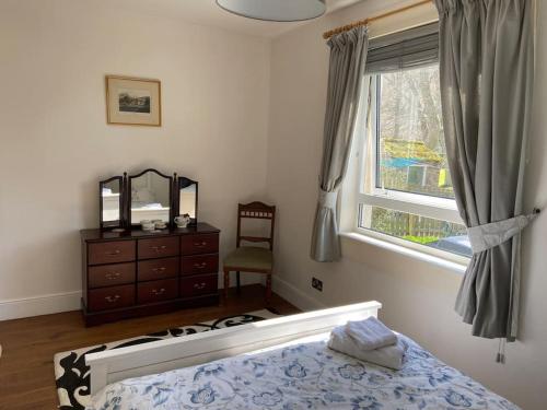 1 dormitorio con 1 cama, vestidor y ventana en Lovely little house in Yarrowford - Yarrow Valley en Broadmeadows