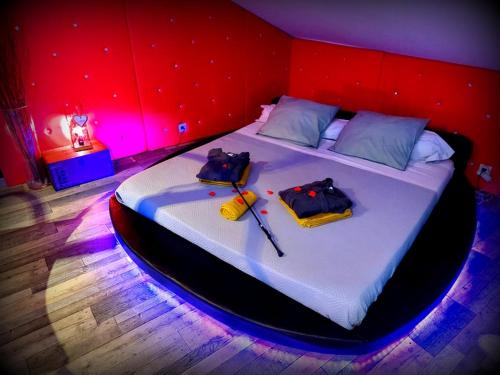 a bedroom with a large bed with a red wall at PLAISIR DES SENS in Roanne