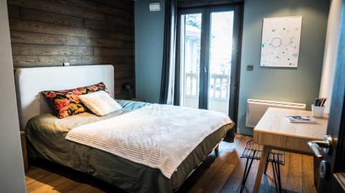 een slaapkamer met een bed en een houten muur bij Appartement Relax in Bourg-Saint-Maurice