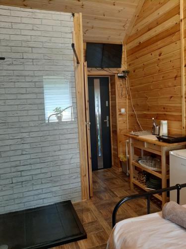 ein Schlafzimmer mit einer Holzwand und einer Tür in einem Zimmer in der Unterkunft Domek dla par agroturystyka siedlisko 