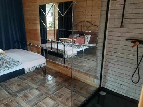 にあるDomek dla par agroturystyka siedliskoのベッド1台が備わるガラスの壁の客室です。
