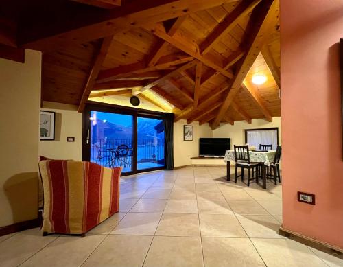 un ampio soggiorno con soffitti in legno e una sala da pranzo di Appartamento Roberta a Musso