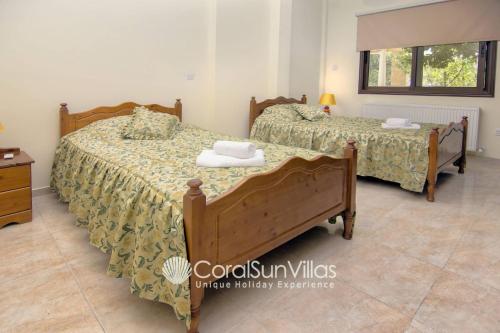a bedroom with two beds and a dresser at Elegant Huge Villa Large Pool, Ideal For Weddings in Kathikas